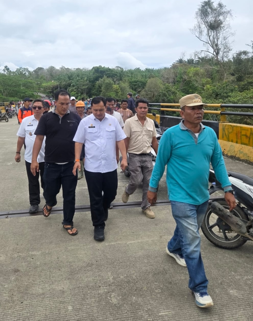 Asisten Kesejahteraan Rakyat dan Pemerintahan Pemkab Deliserdang Citra Effendi Capah dan lainnya saat meninjau jembatan yang ditemukan sepeda motor Kades Liang Pematang. (Waspada/ist).