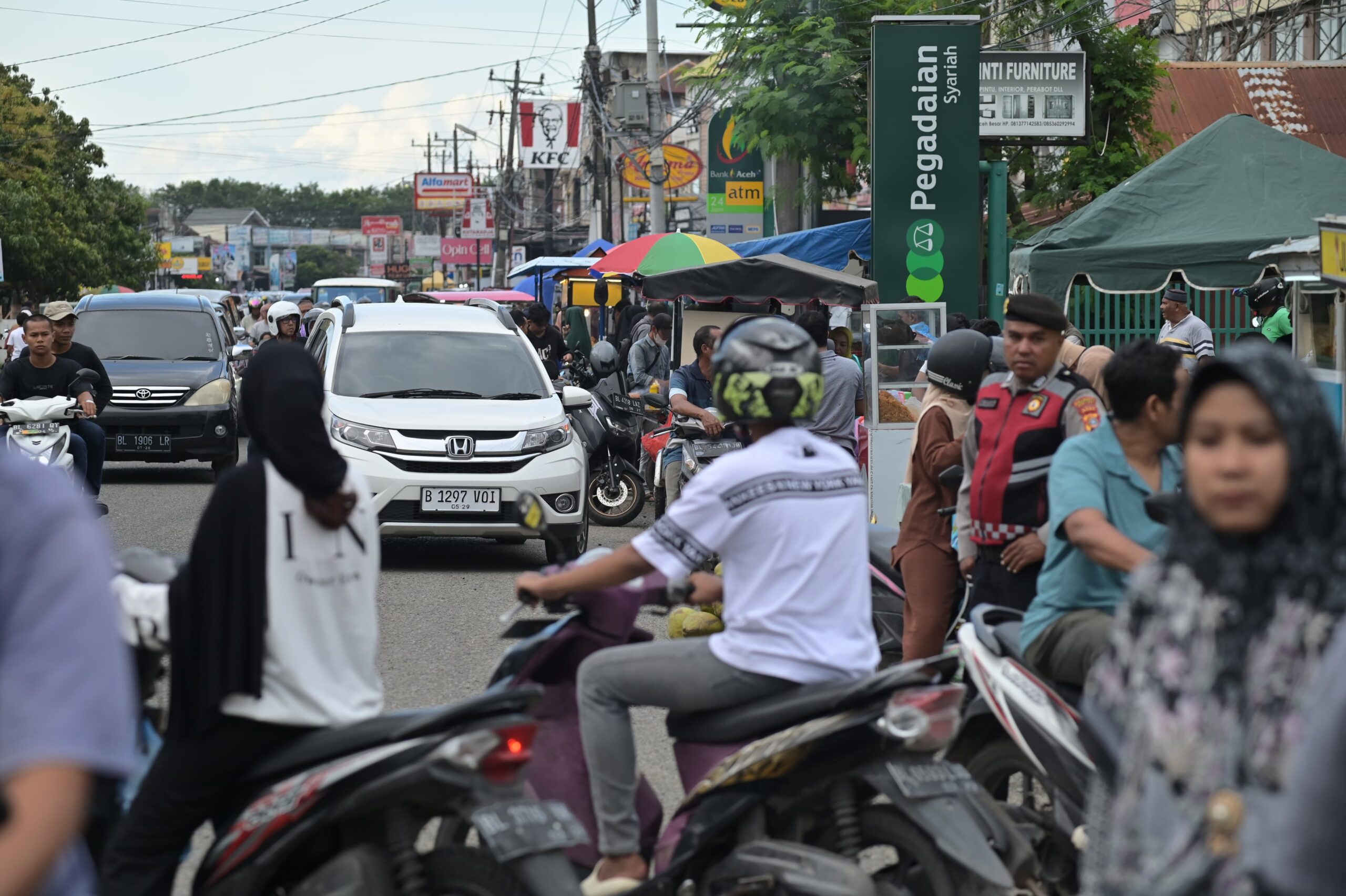 Para pembeli berburu takjil pada puasa pertama bulan Ramadhan 1446 H membuat macet jalanan di sekitar pasar Ketapang Kecamatan Darul Imarah, Aceh Besar, Sabtu (1/3) sore. (Waspada/Zafrullah)