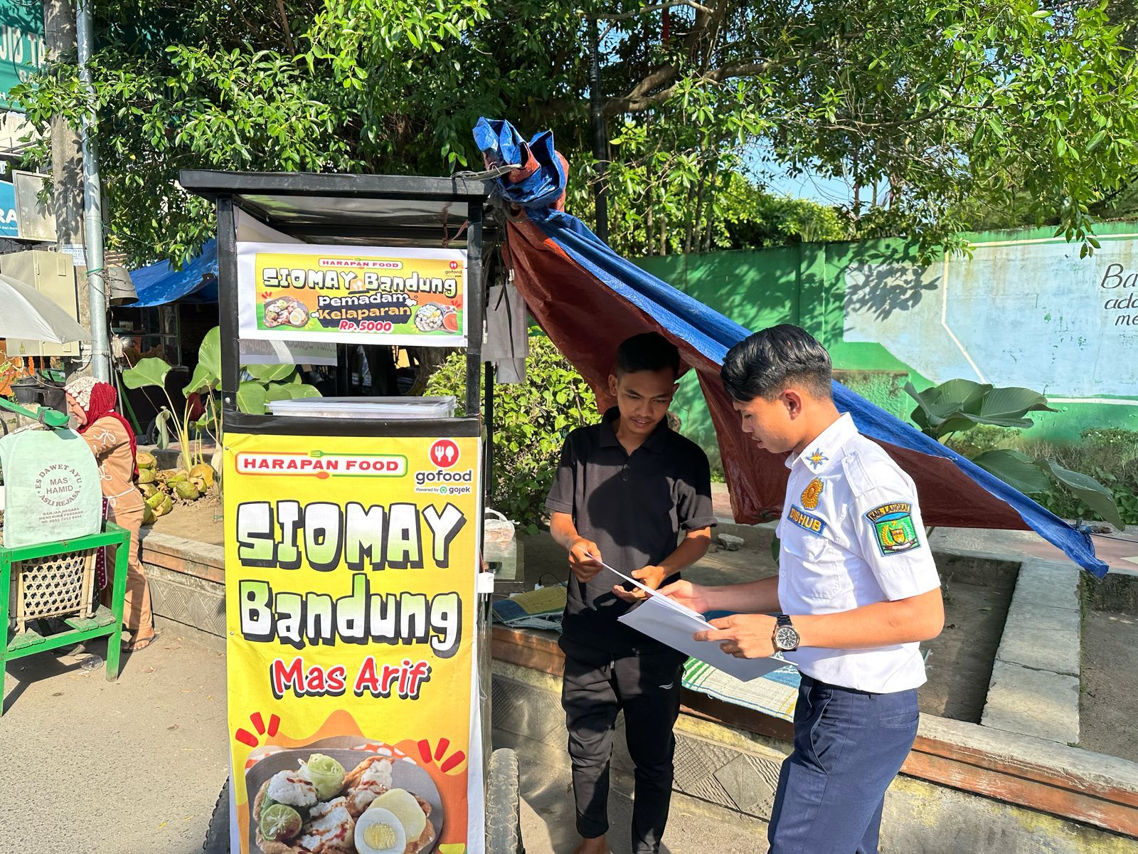 Petugas Dinas Perhubungan Langkat memberikan surat kepada pedagang takjil di Jalan Proklamasi Stabat agar tidak menggunakan badan jalan untuk berdagang demi mengurangi macat sore hari dan juga surat berisi agar pedagang tidak memberikan uang kepada juru parkir. Waspada/Ist