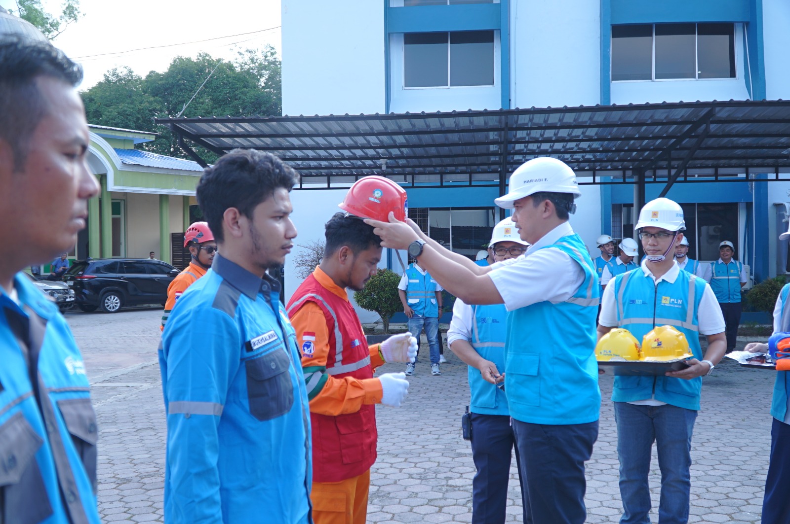 Senior Manager Distribusi, Hariadi Fitrianto saat memasangkan helm kepada pengawas Pekerjaan sebagai wujud penerapan budaya safety.