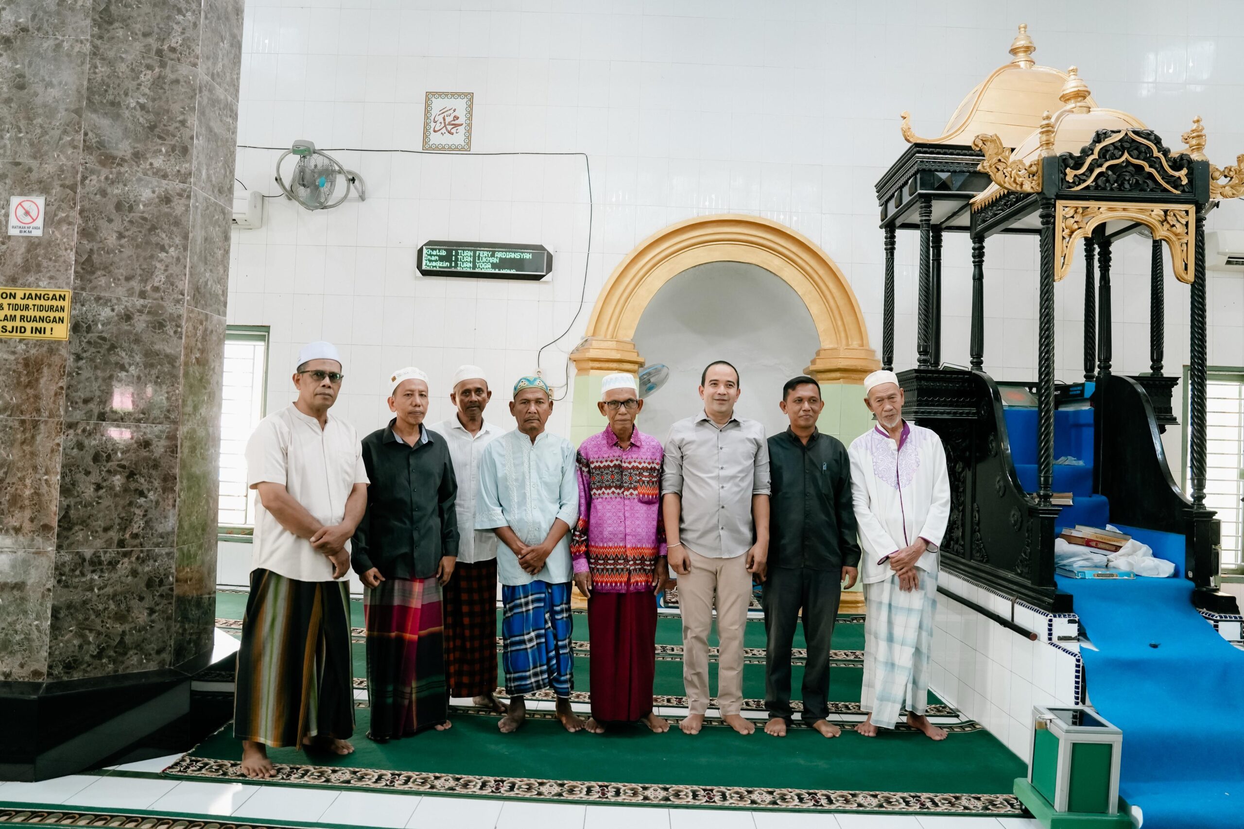 Ketua DPRD Deliserdang Zakky Shahri, Kades Rantau Panjang Muhammad Taher dan lainnya berfoto bersama di peninggalan Mimbar yang terbuat dari kayu mahoni. (Waspada/Edward Limbong).