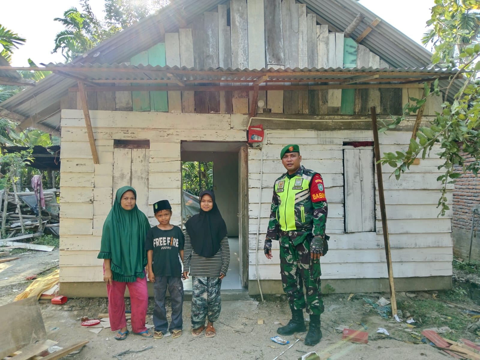 Serda Ismail anggota Koramil Karang Baru jajaran Kodim 0117/ Aceh Tamiang bersama keluarga Surendah seusai dilakukan perbaikan rumah Surendah. (Waspada/Yusri).