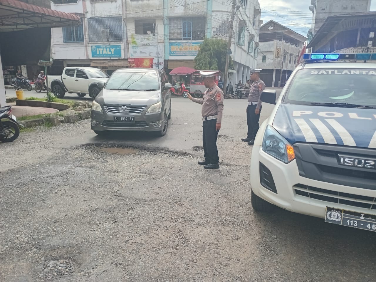 Satlantas Polres Abdya, mengatur arus lalin kendaraan di jalan rusak, kawasan perempatan Jalan Selamat pusat kota Blangpidie. Kamis (6/3).Waspada/Syafrizal