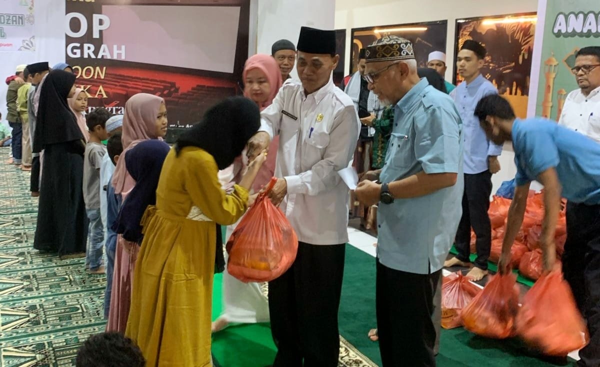 Direktur PT ATC Ahmad Zailani (kanan) bersama Kadis Sosial Kota Padangsidimpuan Jufri Nasution memberikan santunan kepada anak Yatim. Waspada/ist.