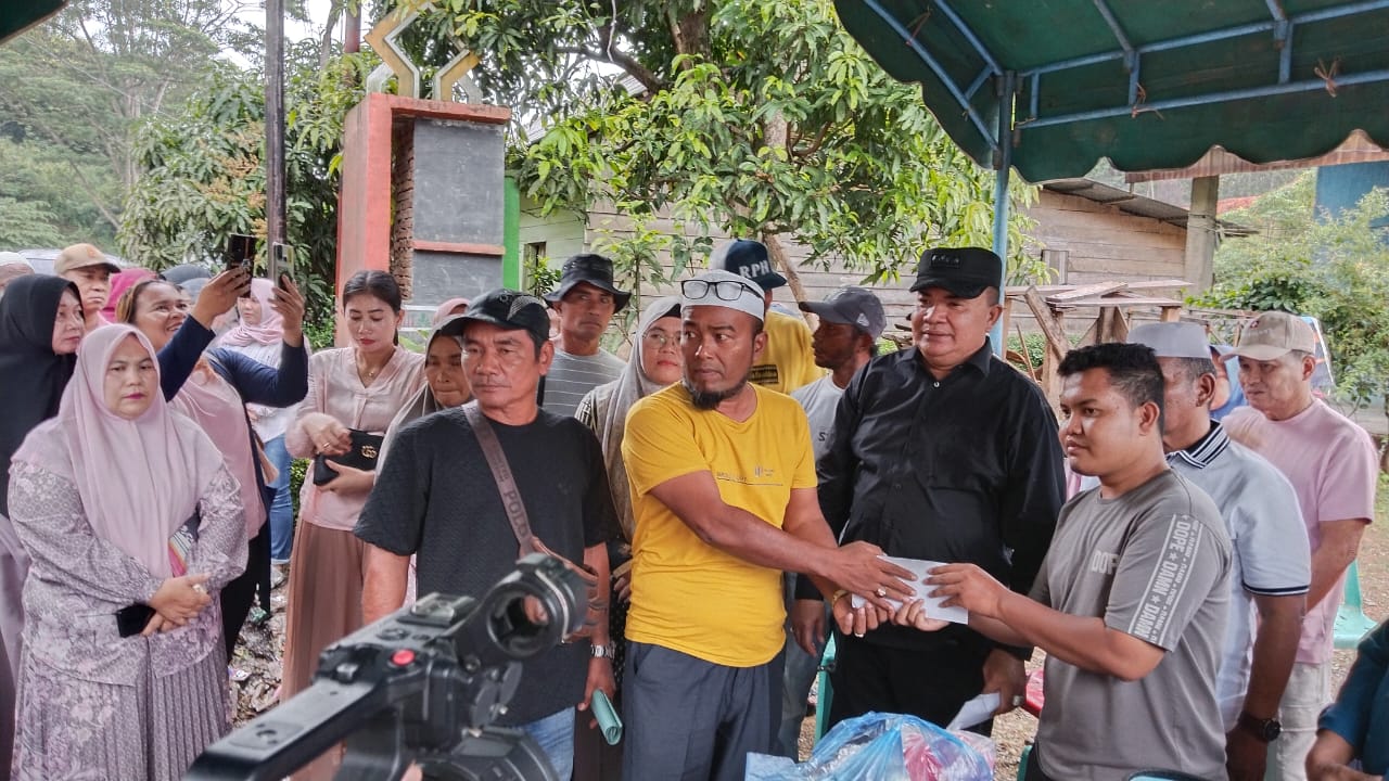 Bupati Salim Fakhry saat menyaksikan penyerahan bantuan masa panik korban kebakaran. Waspada/Seh Muhammad Amin