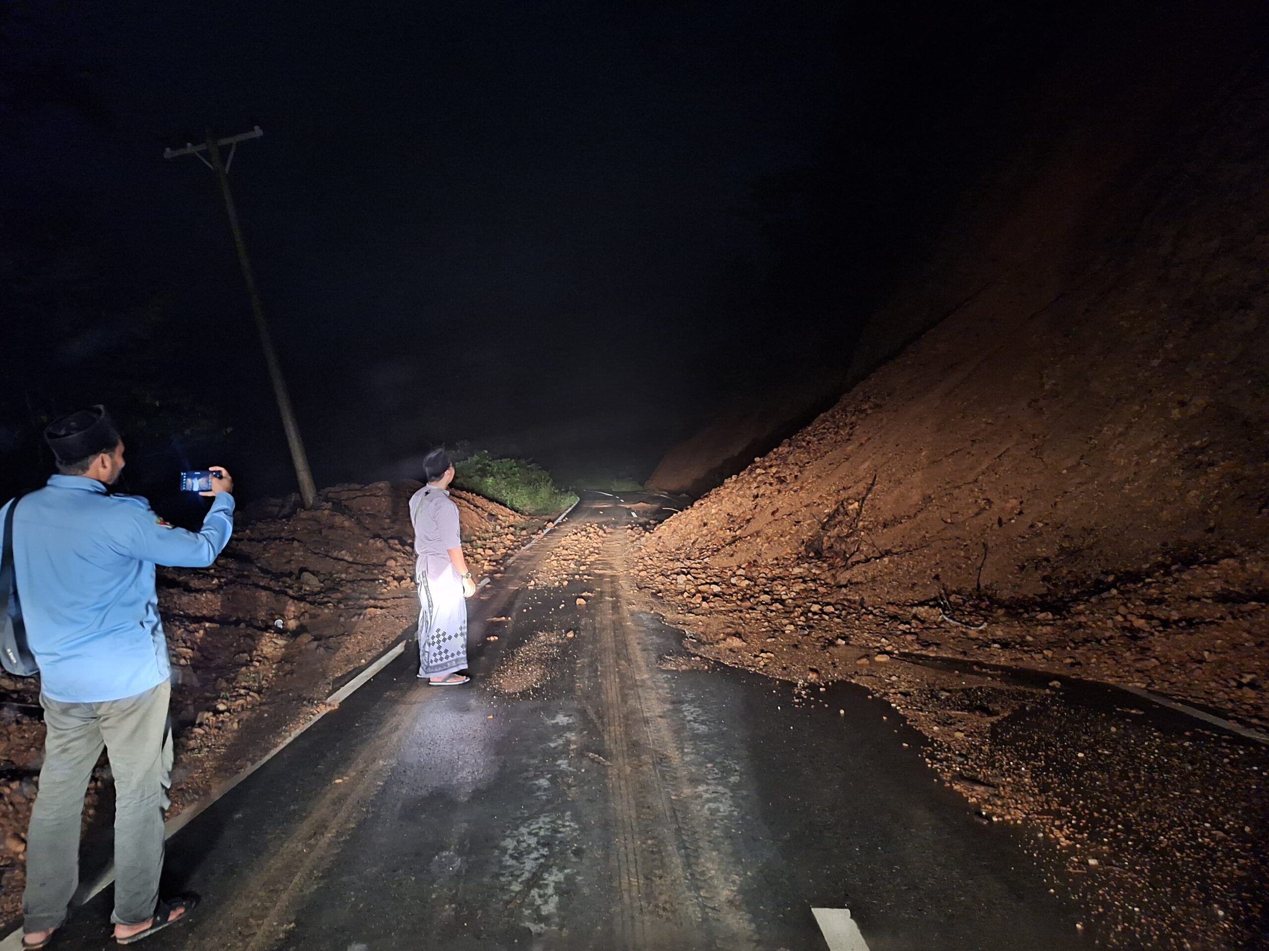 Pengguna jalan melihat tanah longsor yang menutupi sebagian badan jalan lintas Peureulak - Blang Kejeren, tepatnya di Gunung Bunin, Serbajadi, Aceh Timur, Sabtu (8/3) malam. Waspada/Muhammad Ishak