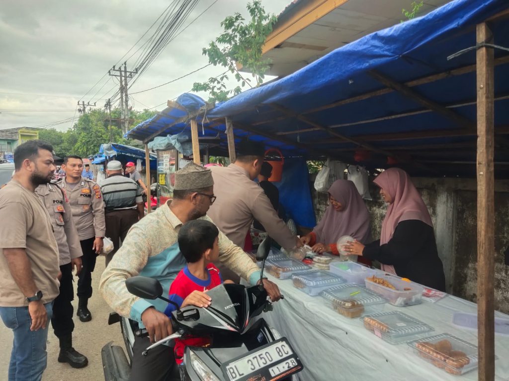 Kapolsek Darussalam, Iptu Adam Maulana, sedang memborong takjil dari salah seorang pedagang di kawasan Lambaro Angan, Gampong Lambada, untuk kemudian dibagikan kepada pengguna jalan. (Waspada/Zafrullah)