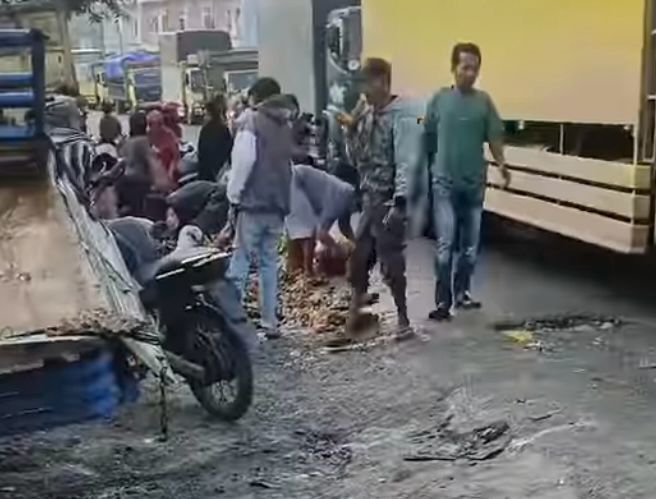 Sejumlah warga menjarah telur ayam dalam kecelakaan truk ekspedisi dengan mobil bak terbuka (pick up) muatan telur ayam di ruas Jalinsum Torgamba, tepatnya di persimpangan Bis II, Desa Aek Batu, Kec. Torgamba, Kab. Labusel, Minggu (2/3/2025) pagi. Waspada/Ist