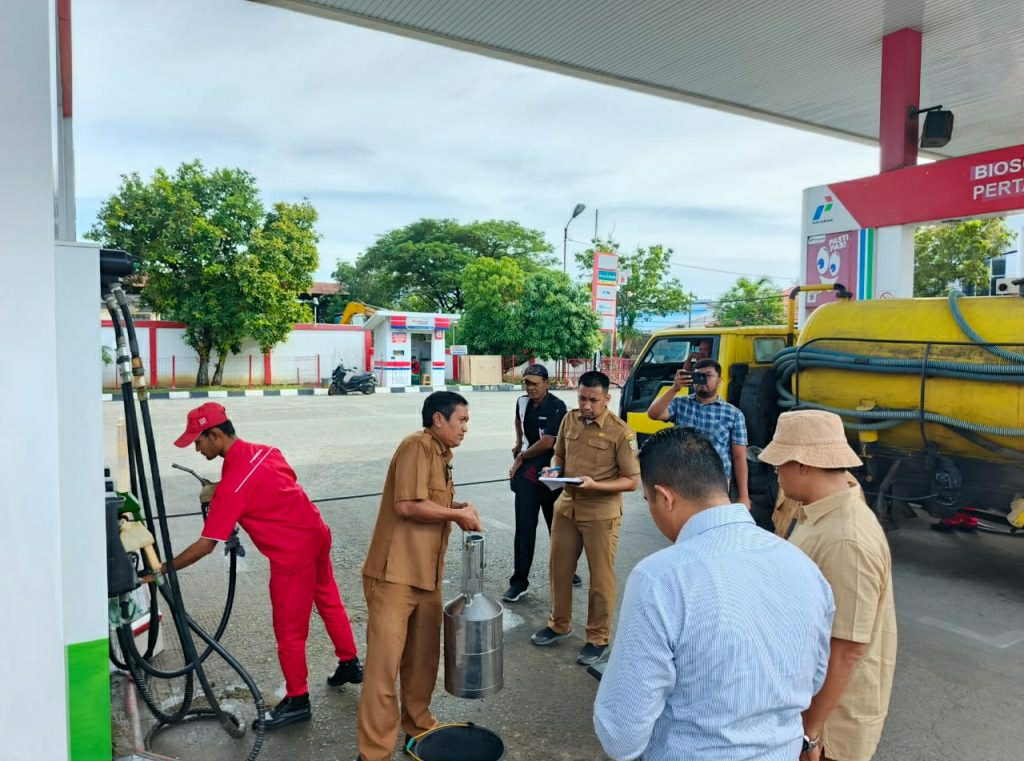 Wakasat Reskrim Polresta Banda Aceh, Iptu Julpandi didampingi Kepala UPTD Metrologi Kota Banda Aceh, Fikri, sedang melakukan pemeriksaan di sebuah SPBUndi Banda Aceh. (Waspada/Zafrullah)