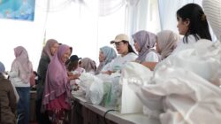 Srikandi PLN saat membagikan sembako pasar murah kepada warga yang sudah memilikykupon penukaran.