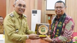 Bupati Simalungun Anton Saragih menyerahkan plakat kepada Kepala BPK RI Perwakilan Provinsi Sumut, Paula Henry Simatupang dalam rangkaian kegiatan entry meeting di Balai Harungguan Djabanten Damanik Kantor Bupati Simalungun, Selasa (11/3).(Waspada/ist).