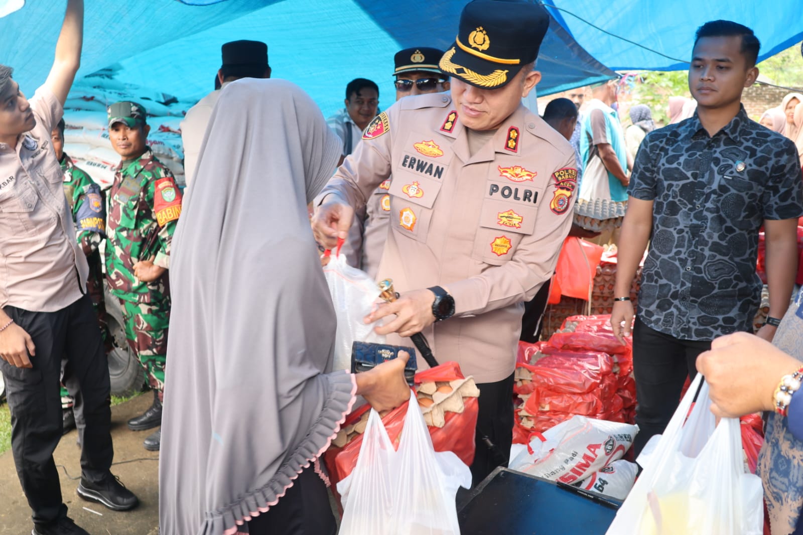 Kapolres Sabang, AKBP Erwan, SH, MH menyerahkan paket pasar murah kepada masyarakat. (Waspada/ist)