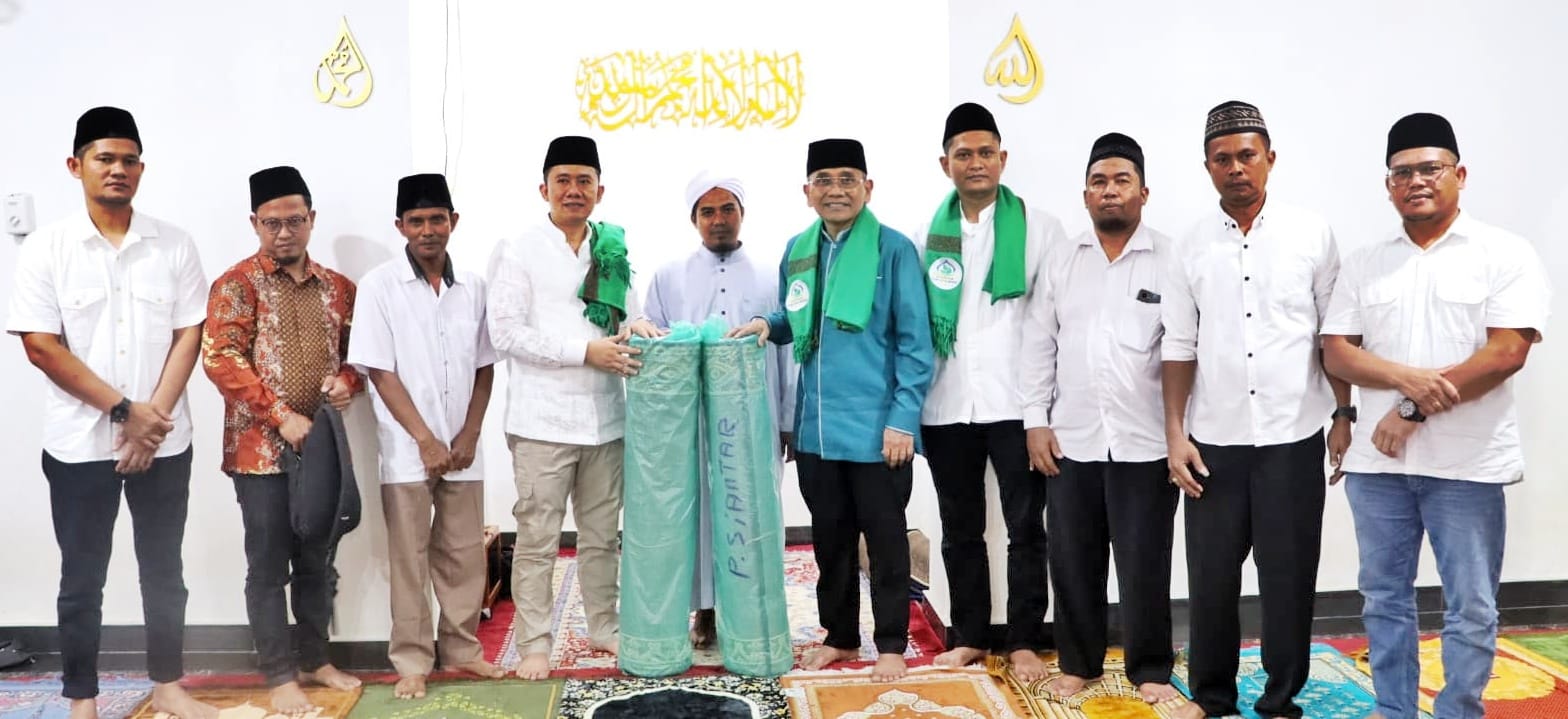 Bupati Simalungun Anton Saragih didampingi Camat Bandar Huluan Akbar Putra Siregar menyerahkan dua gulung sajadah panjang diterima pengurus Yayasan Darul Putera Madina, Darma Putra, Jumat (14/3) malam.(Waspada/ist).