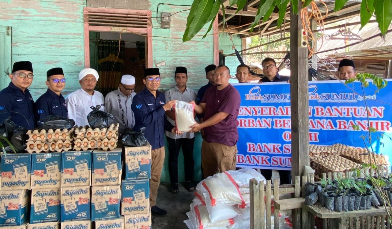 Kepala Bank Sumut Syariah Cabang Padangsidimpuan Hilman Saleh Daulay (kiri) saat menyerahkan bantuan untuk korban banjir kepada Kepala Desa Silaiya, Safritua Nasution di Desa Silaiya, Kecamatan Sayur Matinggi, Tapsel, Minggu (16/3/2025). Waspada/ist.