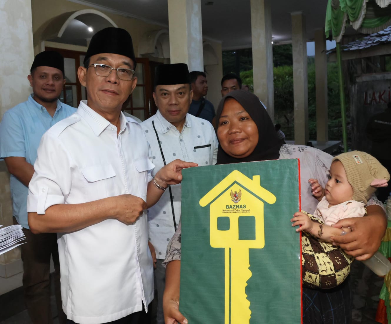 Bupati Tapsel Gus Irawan Pasaribu serahkan bantuan rehab rumah ke warga Kecamatan Sayurmatinggi. (Waspada/Sukri Falah Harahap)