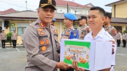 Kapolres Pematangsiantar AKBP Yogen Heroes Baruno (kiri) menyerahkan paket lebaran kepada personel, ASN dan PHL Polres sebagai wujud perhatian pimpinan dalam menyambut Hari Raya Idul Fitri 1446 H di lapangan apel Mapolres, Jl. Sudirman, Selasa (18/3).(Waspada-Ist).