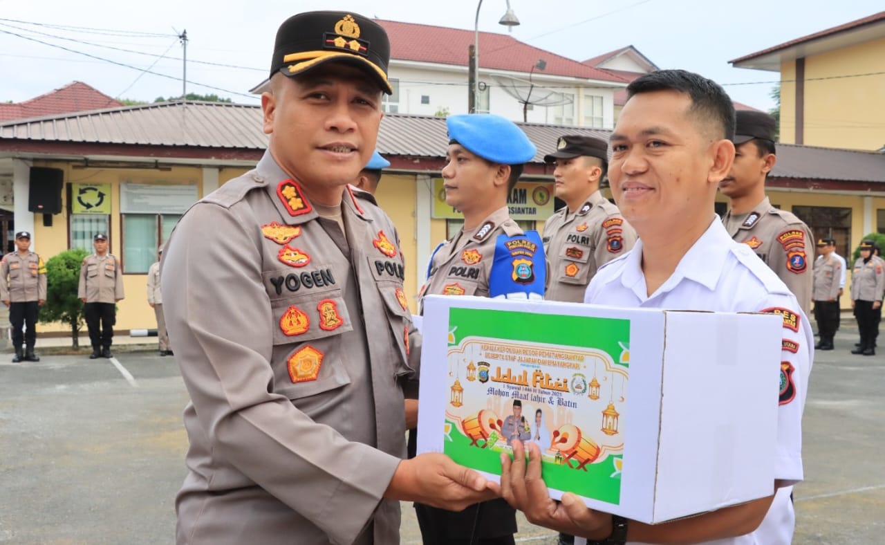 Kapolres Pematangsiantar AKBP Yogen Heroes Baruno (kiri) menyerahkan paket lebaran kepada personel, ASN dan PHL Polres sebagai wujud perhatian pimpinan dalam menyambut Hari Raya Idul Fitri 1446 H di lapangan apel Mapolres, Jl. Sudirman, Selasa (18/3).(Waspada-Ist).