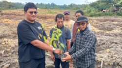 MASYARAKAT Desa Sitapongan, Andi Lumban Gaol menerima bibit pohon durian dari pihak pengusaha untuk ditanam di lahan bukaan pertanian. Waspada/Andi Siregar