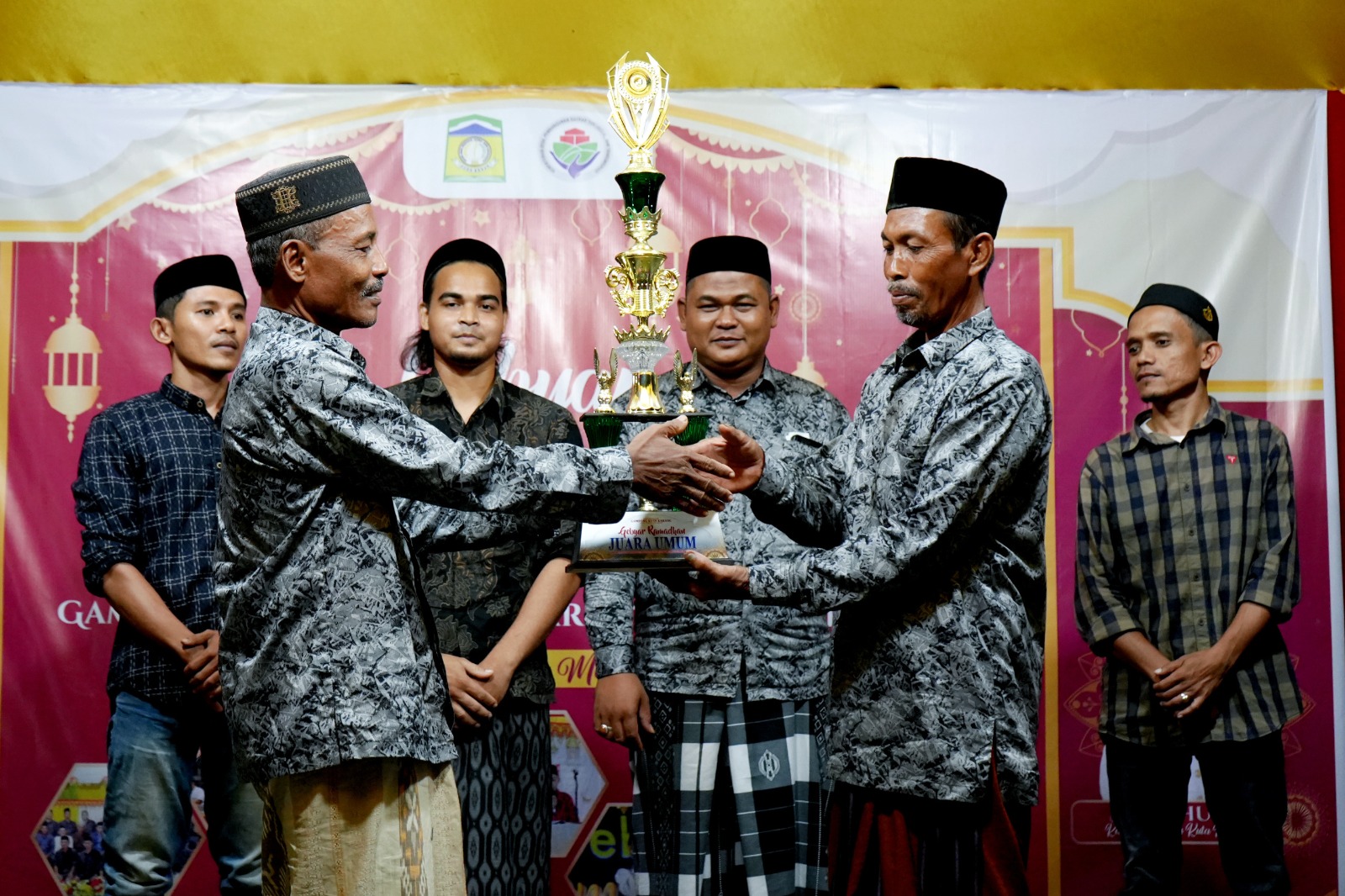 Keuchik Gampong Kuta Karang Suria Husin menyerahkan Tropi Juara Umum kepada Kepala Dusun Tgk Chiek, Buchari disaksikan oleh ketua Pemuda Syarifuddin dan Ketua Panitia Ahmad Farhan, pada penutupan Gebyar Ramadhan 1446 H gampong Kuta Karang, Darul Imarah Aceh Besar, Jumat (21/3/2025). Waspada/Ist