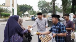 Ketua Komisi II DPRD Deliserdang, Muhammad Ilham Pulungan dan Anggota Komisi II DPRD Deliserdang Sehat Harianto Sembiring membagikan takjil kepada pengendara sepeda motor. (Waspada/Edward Limbong).