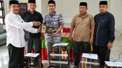 Wabup Aceh Besar, Drs. Syukri, menyerahkan cenderamata berupa kain sarung kepada para imeum masjid, dan para tokoh agama lainnya. (Waspada/Ist)