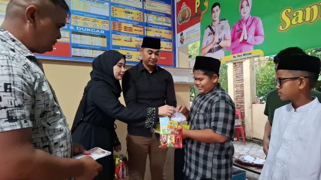 Kapolsek Blang Bintang Polresta Banda Aceh, Ipda Mirzani dan ibu Bhayangkari saat memberikan santunan kapada anak yatim yang berada di wilayah hukumnya. (Waspada/Ist)