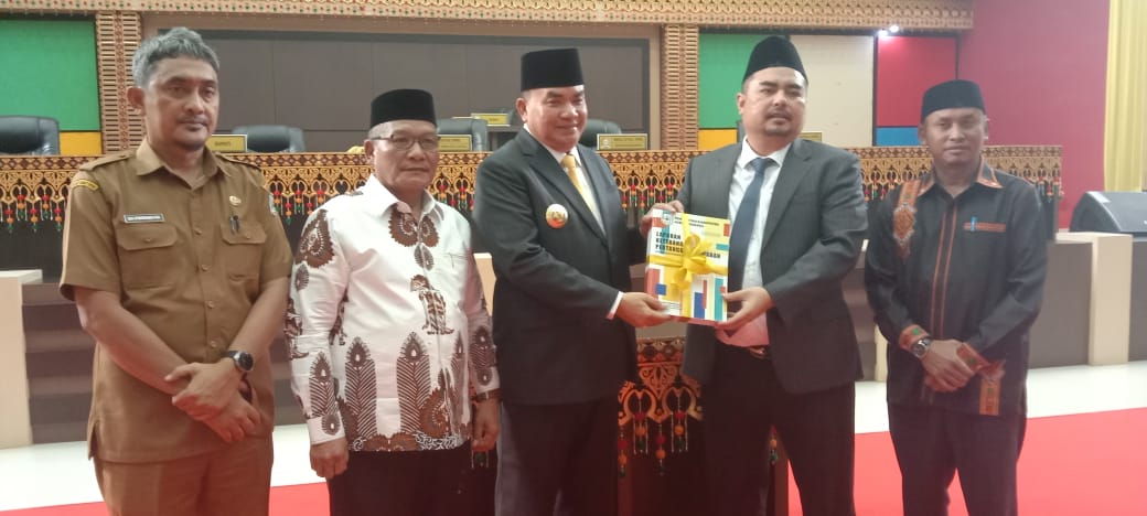 Bupati HM Salim Fakhry, menyerahkan buku LKPJ 2024 kepada Ketua DPRK, Deni Febrian Roza.(Waspada/Ali Amran).